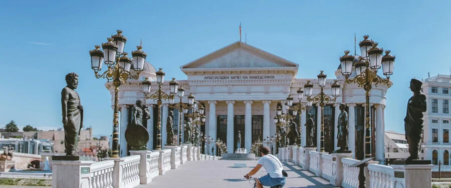 A monumental arch and surrounding city buildings in North Macedonia.